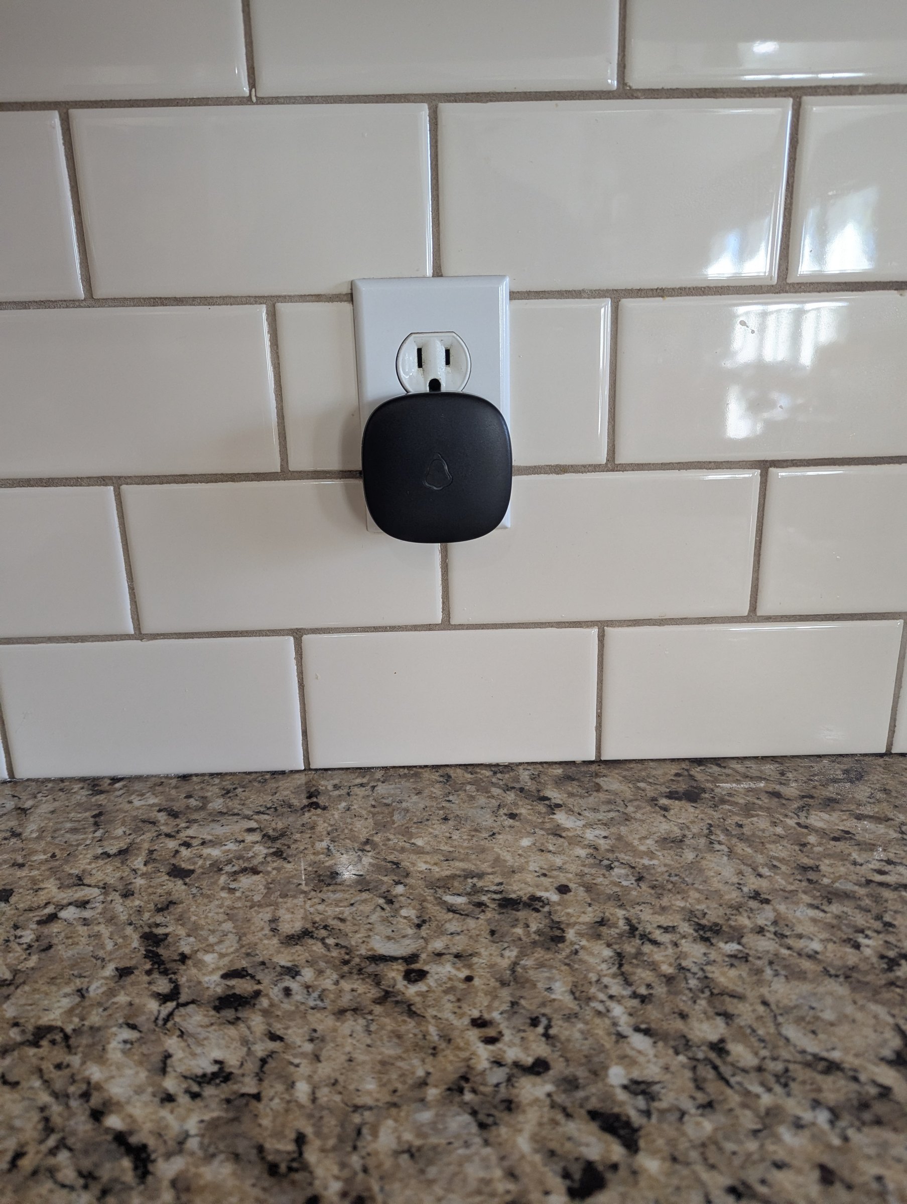 The Alert Base plugged into a kitchen outlet, light off, waiting