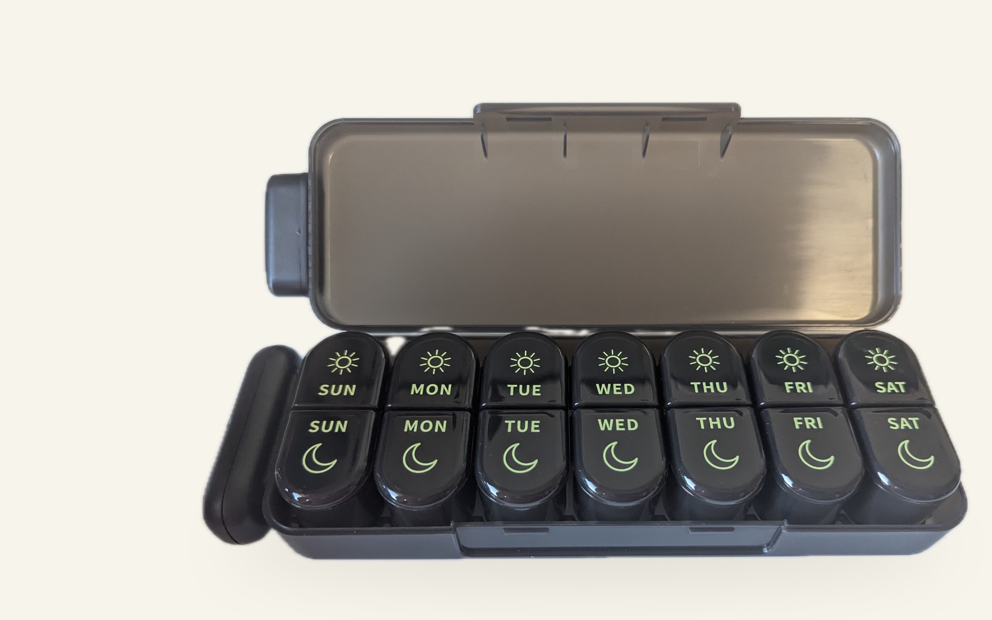 The DailyDoseBox organizer open, showing seven day pods with sun and moon compartments