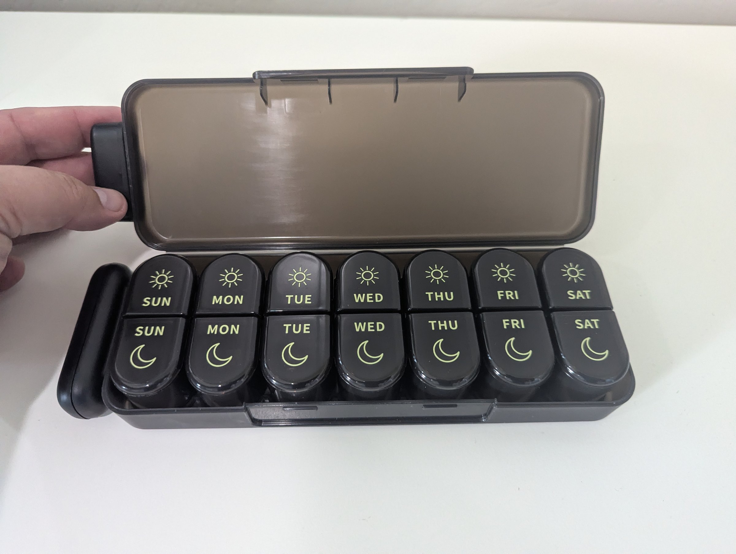 The organizer with the lid open and the seven pods in a row